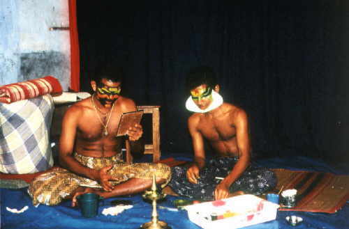 Kathakali-Dancers in Cochin putting on their make-up with natural colors